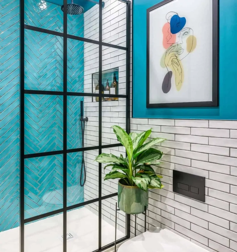 Colourful contemporary bathroom with blue glass screen, artwork and greenery