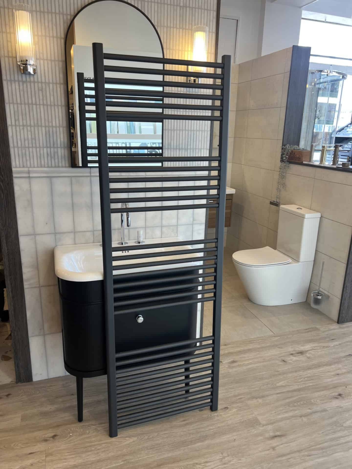Tall black heated towel rail in a contemporary bathroom