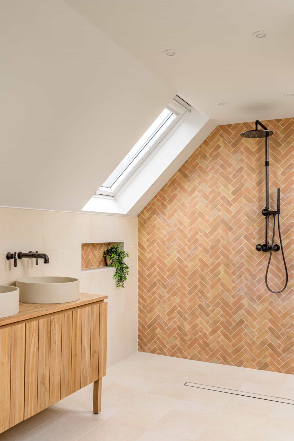 Contemporary attic bathroom with timber herringbone shower wall and black fittings