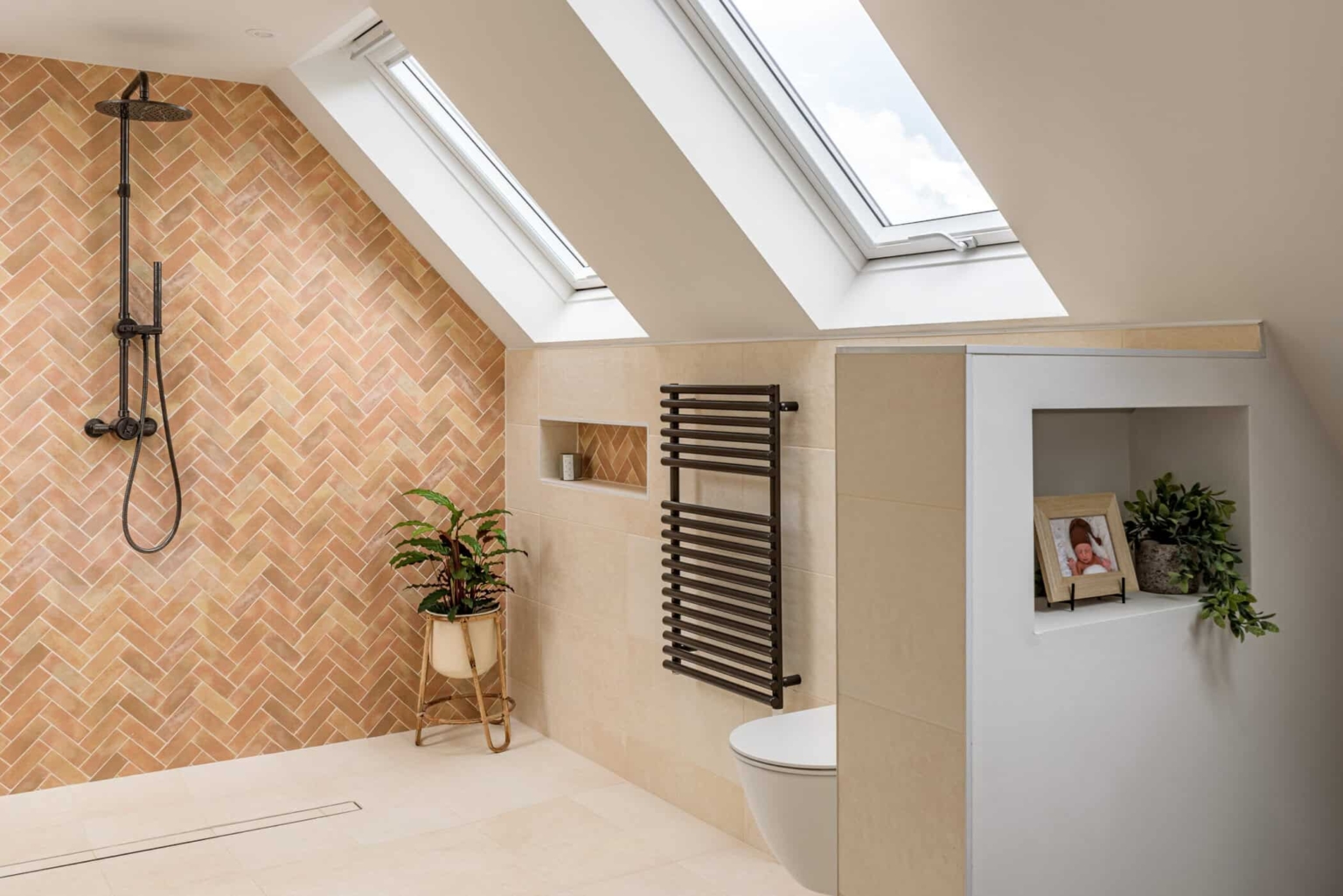 Attic bathroom with timber herringbone wall, skylights and black heated towel rail