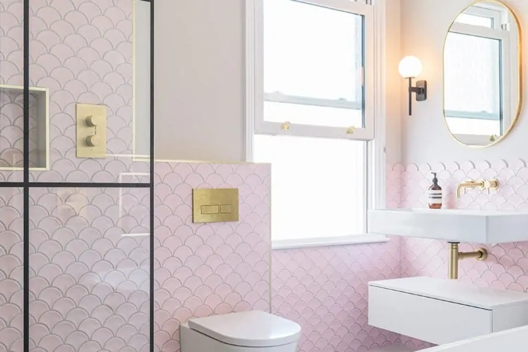 Soft pink bathroom with vanity, round mirror and contemporary fittings
