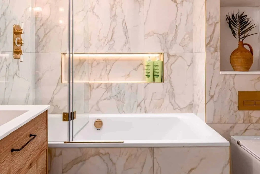 Marble effect shower with illuminated niche and brushed brass fittings