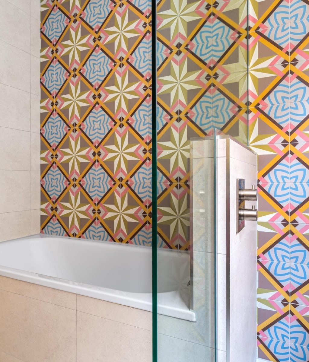 Colourful geometric bathroom tiles with brass framed shower screen