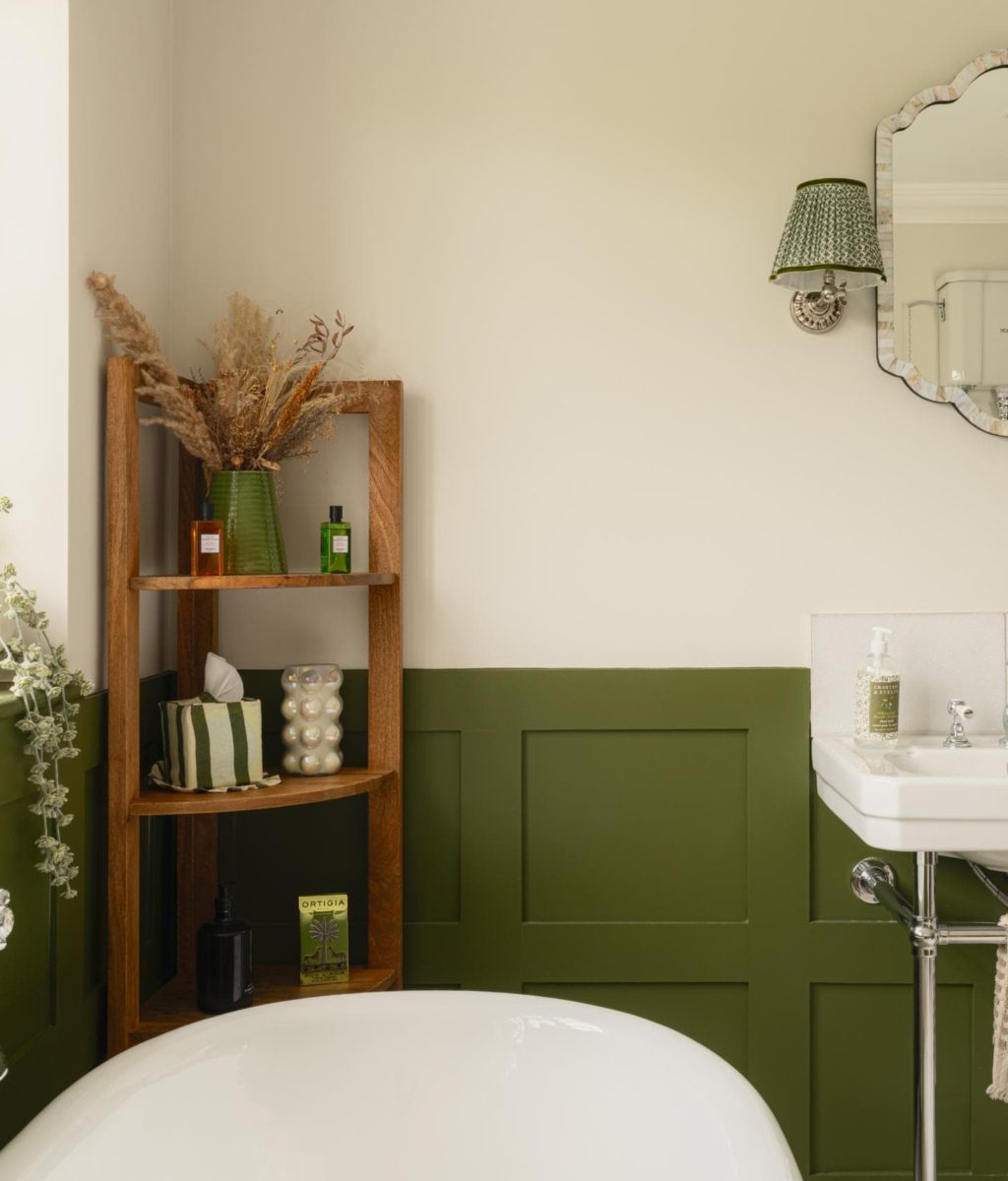 Green panelled bathroom with traditional basin and neutral upper walls