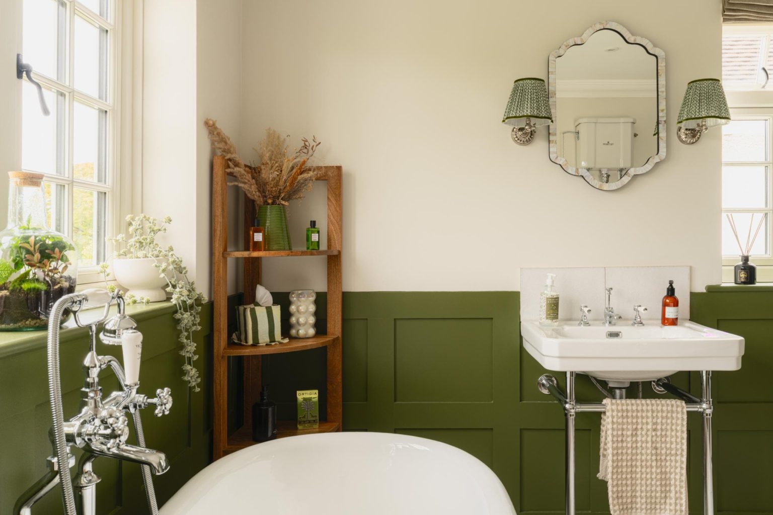 Green panelled bathroom with traditional basin and neutral upper walls
