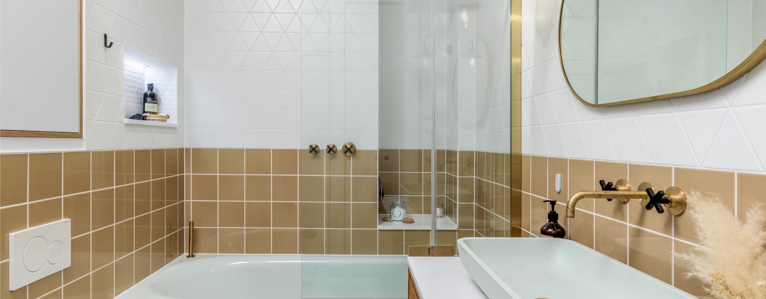 Neutral walk-in shower with glass screen and brushed brass fittings