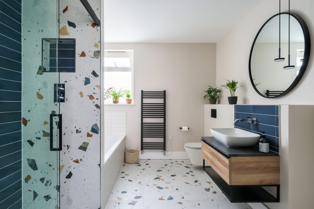 Bright modern bathroom with fitted vanity, mirror and walk-in shower