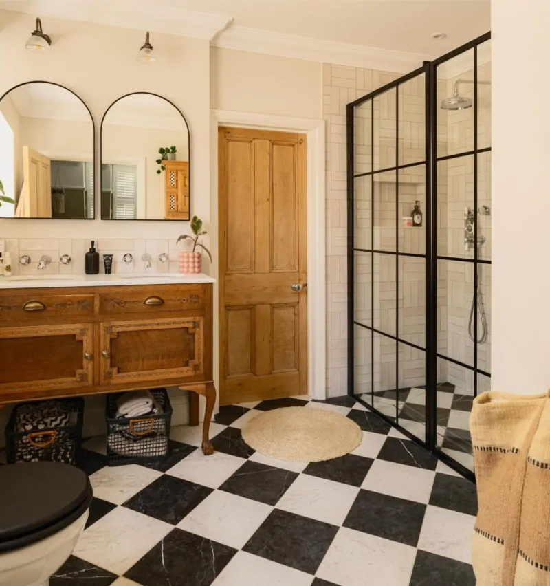Contemporary bathroom with timber vanity, arched mirrors and black framed shower