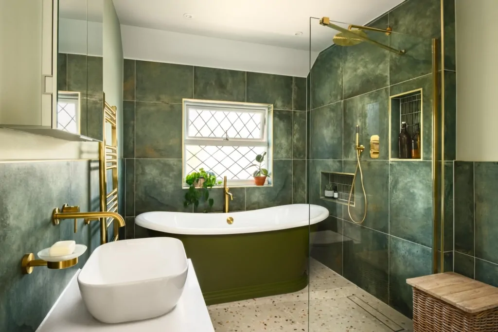 Contemporary bath beneath a window with green marble effect wall tiles