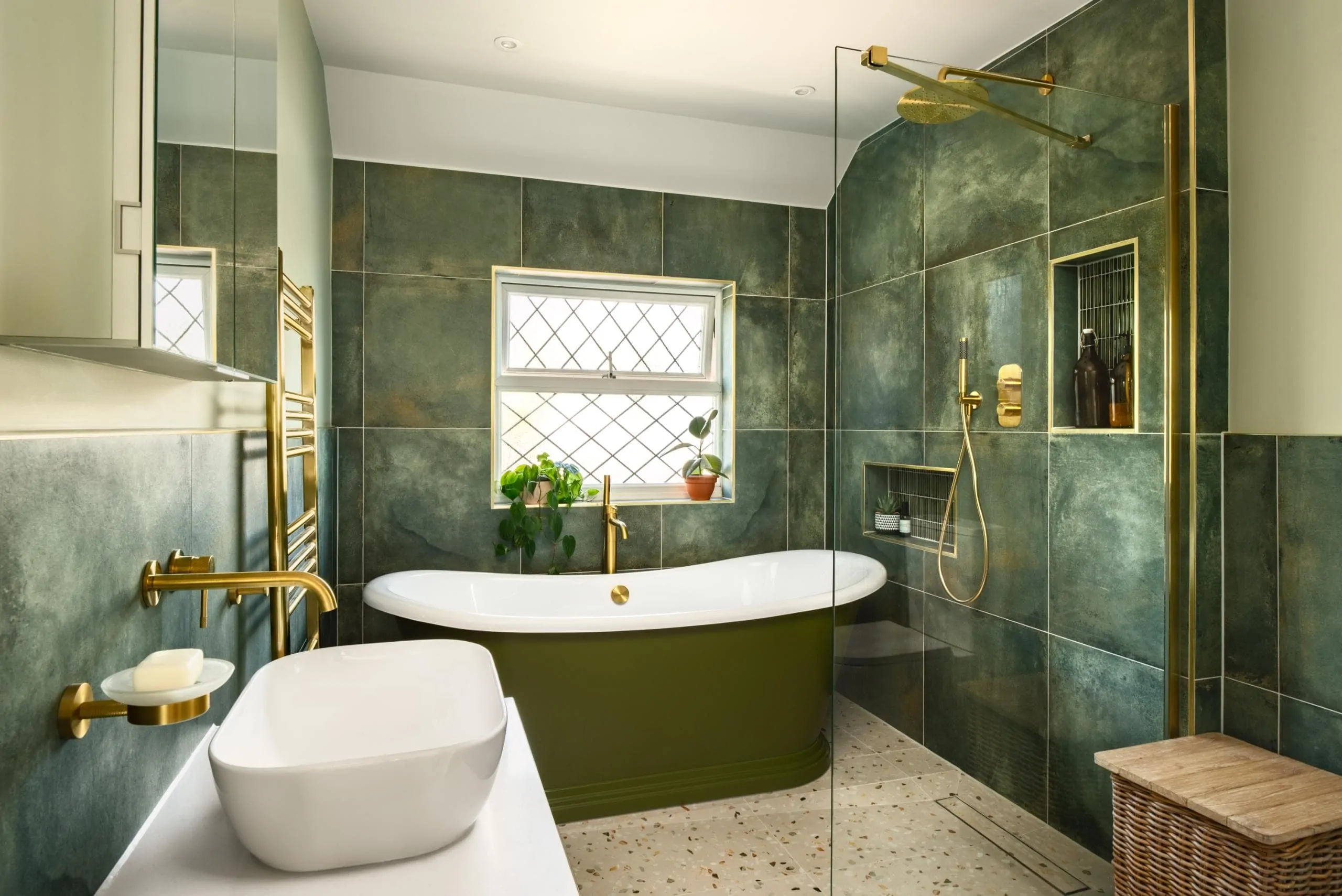 Contemporary bath beneath a window with green marble effect wall tiles