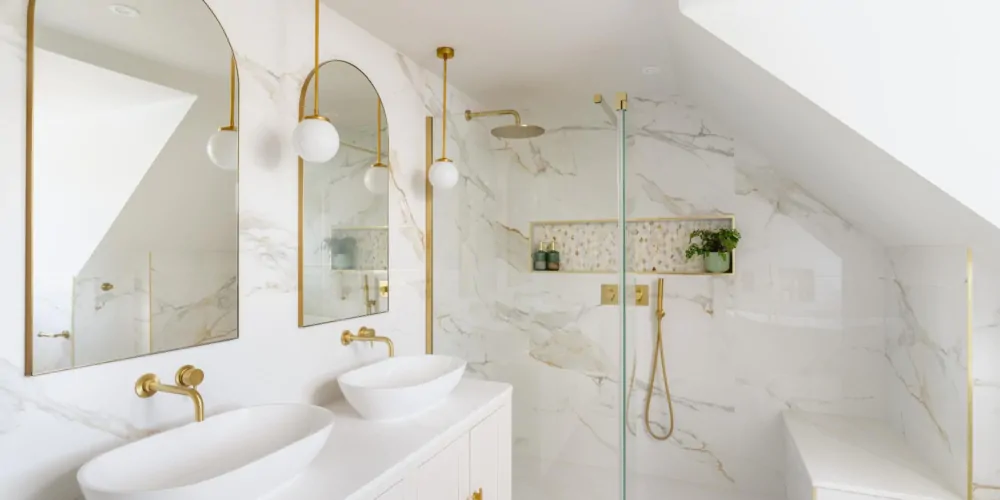 Bright marble effect bathroom with glass shower screen and arched mirrors