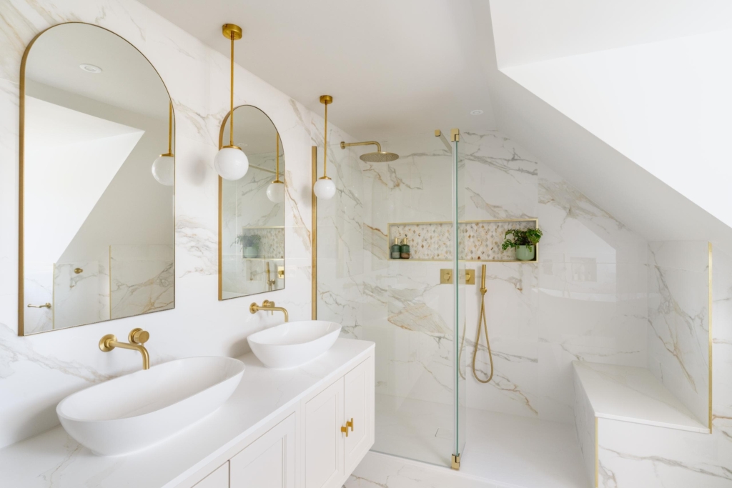 Bright marble effect bathroom with glass shower screen and arched mirrors