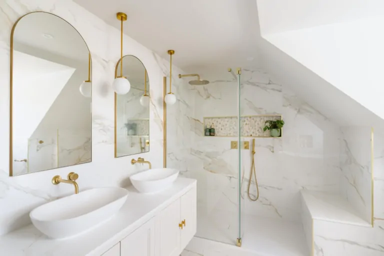 Bright marble effect bathroom with glass shower screen and arched mirrors