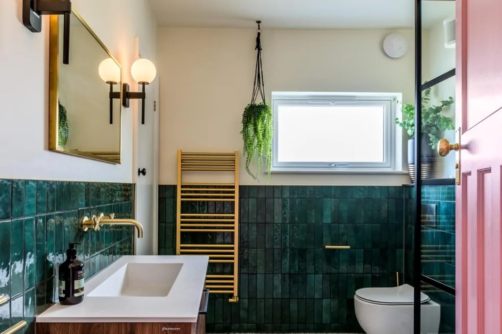 Green tiled bathroom with wall mirror, black lighting and natural light