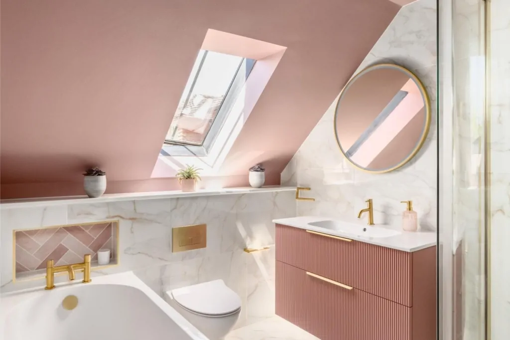 Pink attic bathroom with skylight, round mirror and marble effect finishes