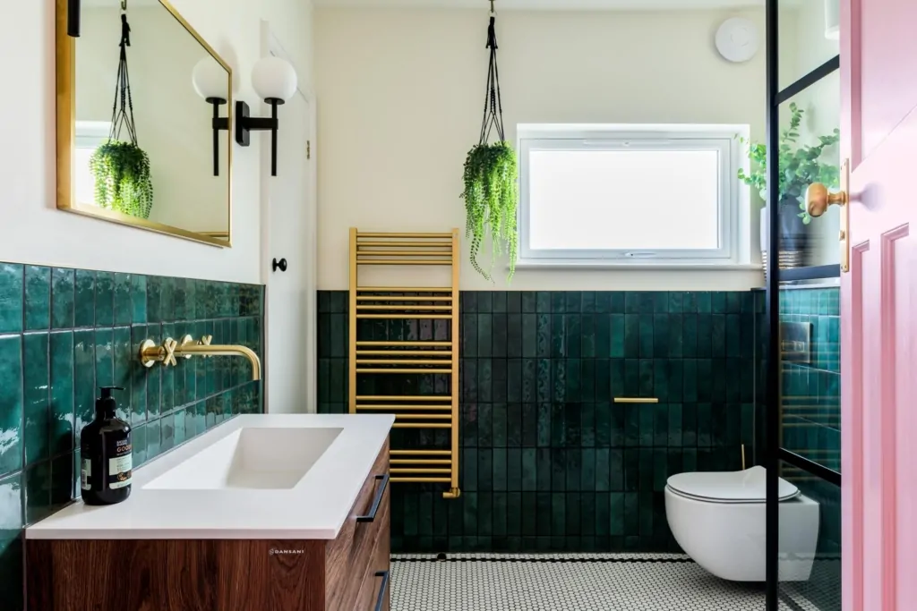 Green tiled bathroom with window, heated towel rail and black wall lighting