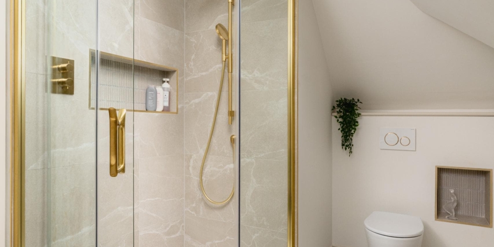 Contemporary walk-in shower with brass fittings and arched bathroom mirror