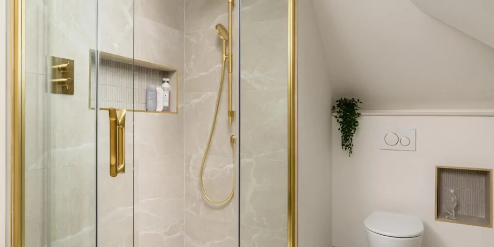 Contemporary walk-in shower with brass fittings and arched bathroom mirror