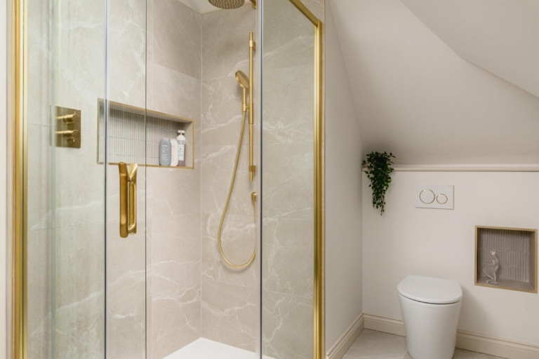 Contemporary walk-in shower with brass fittings and arched bathroom mirror