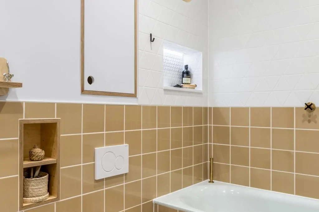 Contemporary bathroom cabinetry with recessed shelving and warm beige tiles