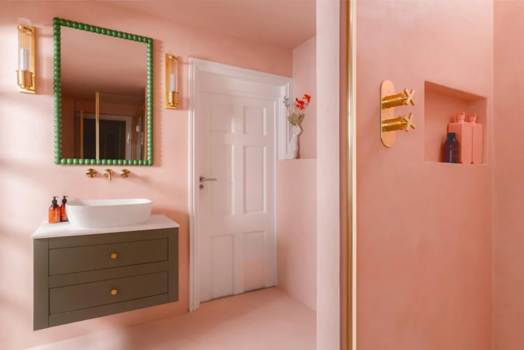 Contemporary pink bathroom with brass fittings and bespoke storage