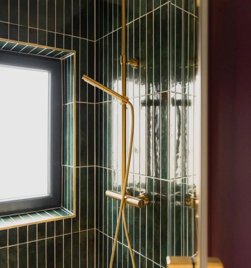 Luxury shower with brass fittings, dark tiles and botanical bathroom design