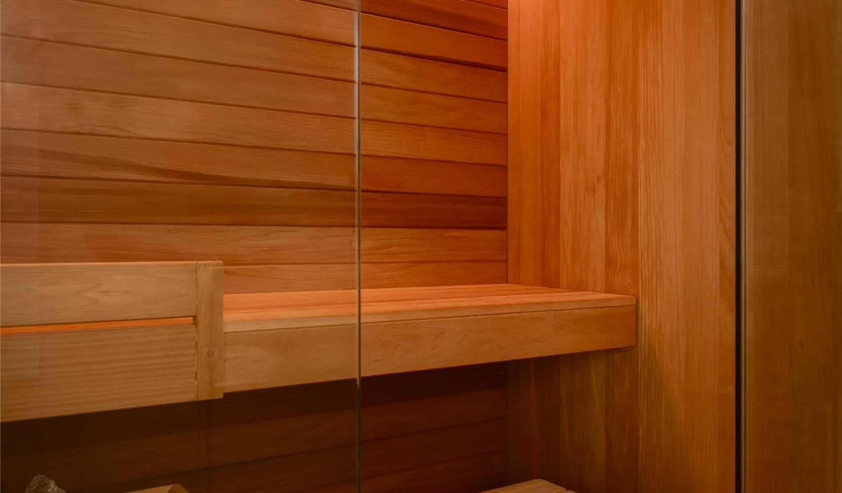 Bespoke timber sauna interior with wooden bench and warm ambient lighting