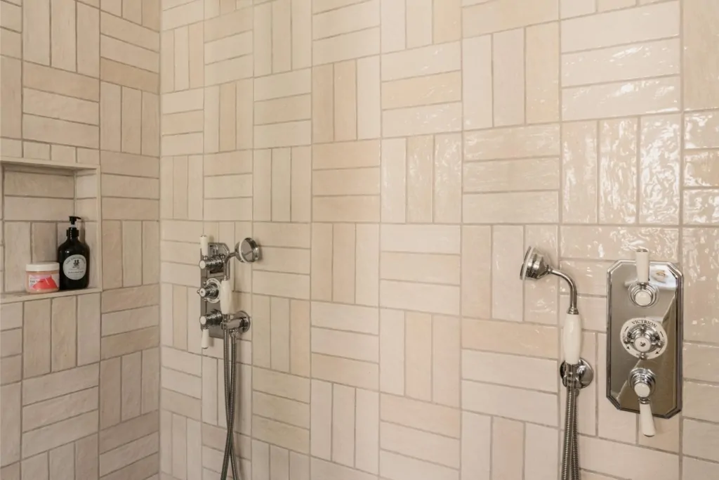 Bright white tiled shower with chrome fittings and overhead rainfall shower
