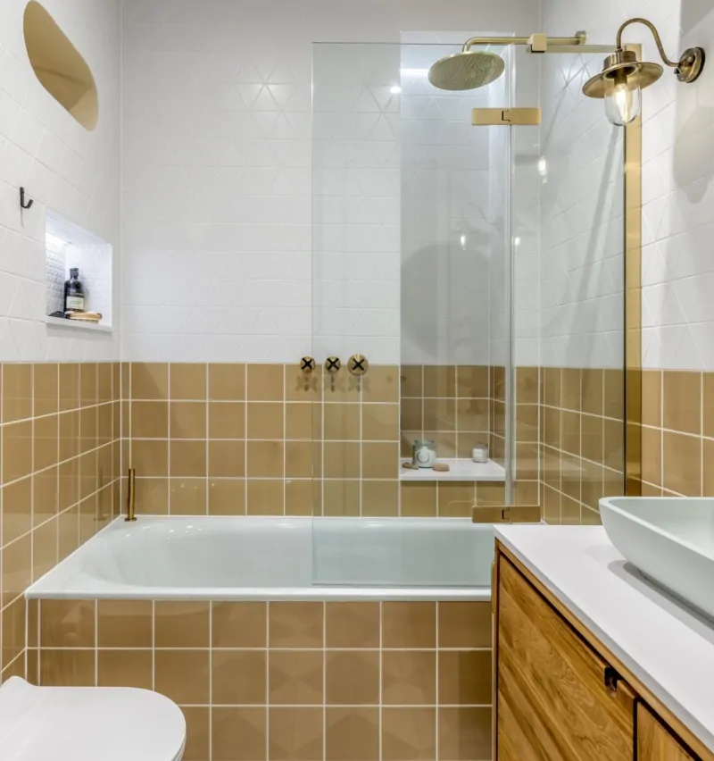 Walk-in shower with glass screen, rainfall shower and warm neutral tiles