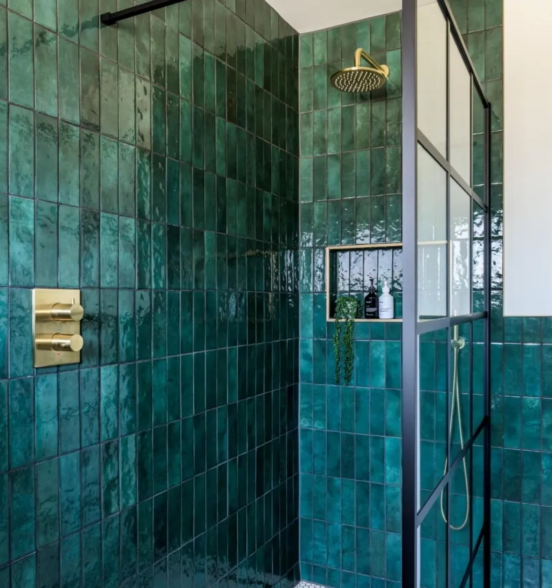 Walk-in shower with glass screen and rich green textured tiles