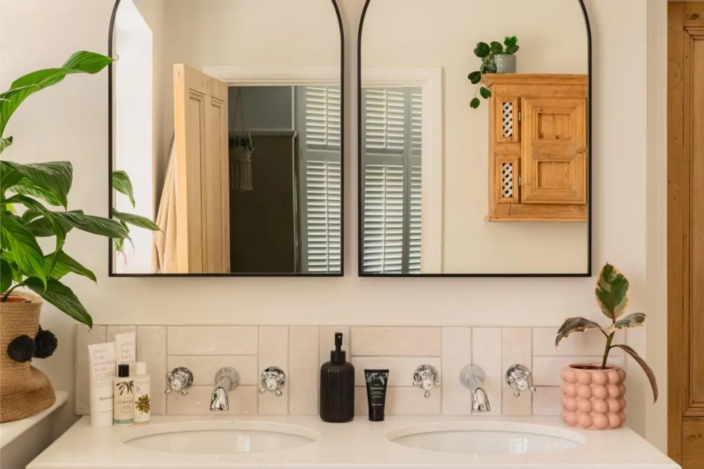 Arched bathroom mirror with greenery and bespoke timber wall cabinet