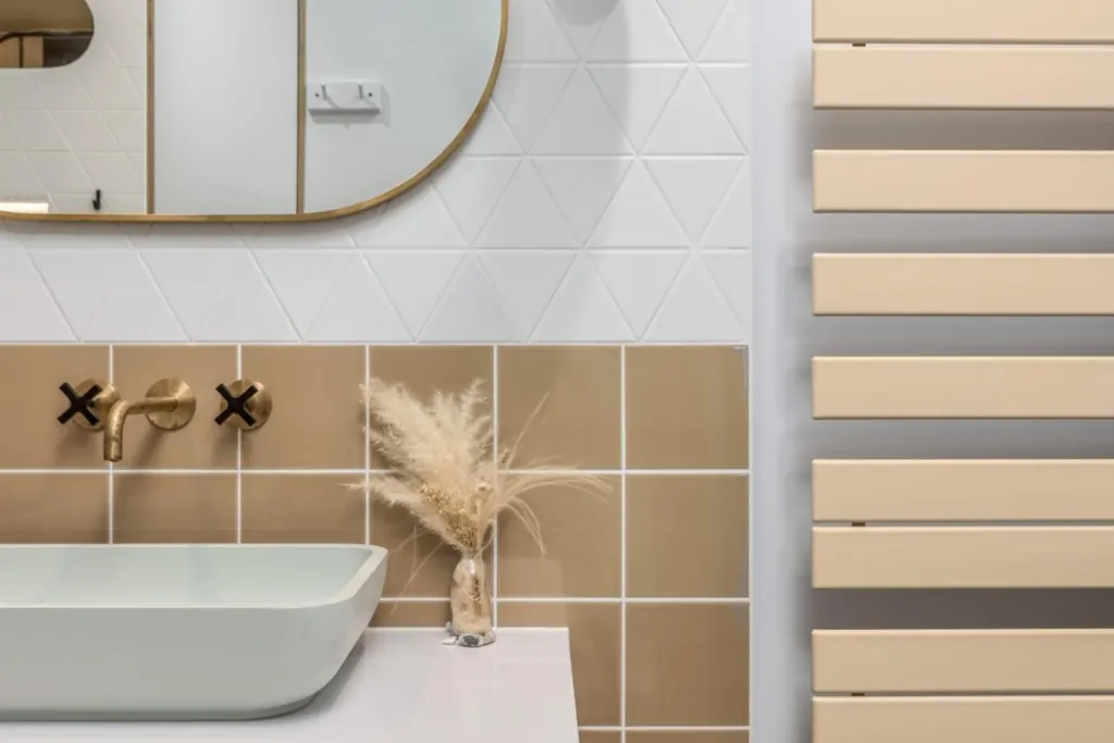 Neutral bathroom vanity with mirror, gold fittings and heated towel rail