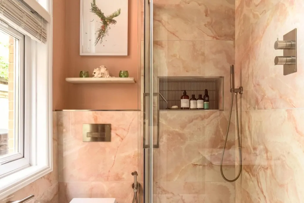 Contemporary pink bathroom with bespoke storage and warm neutral finishes