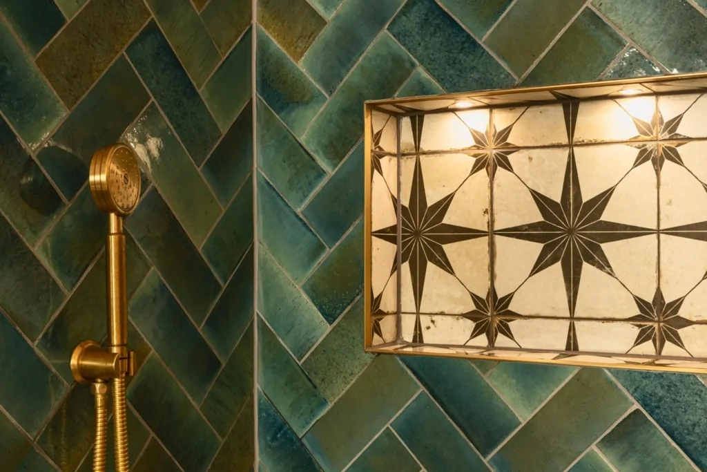 Dark green herringbone bathroom tiles with decorative geometric wall light
