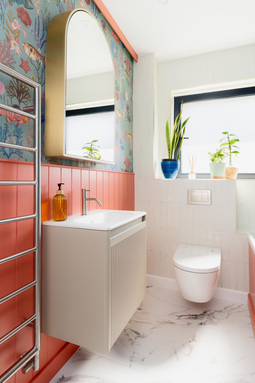 Modern bathroom basin with coral tiles, mirror and natural light