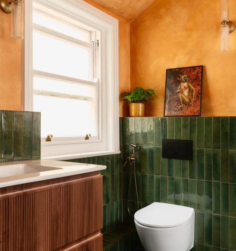 Bespoke bathroom with deep green tiles, warm plaster walls and timber vanity