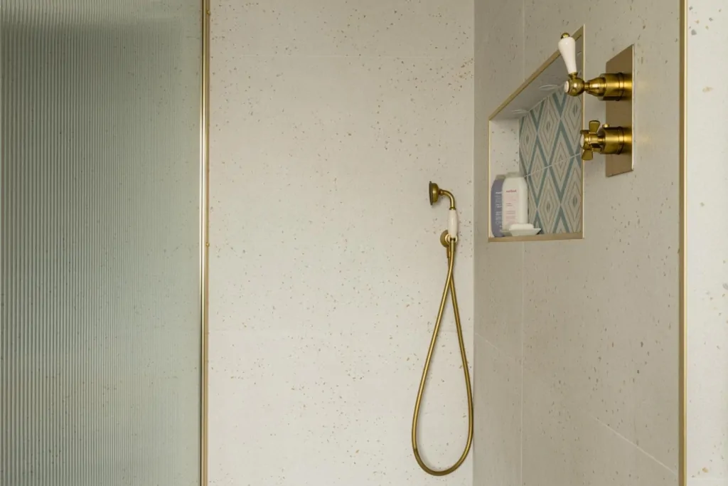 Minimal walk-in shower with white tiles and brushed brass shower fittings