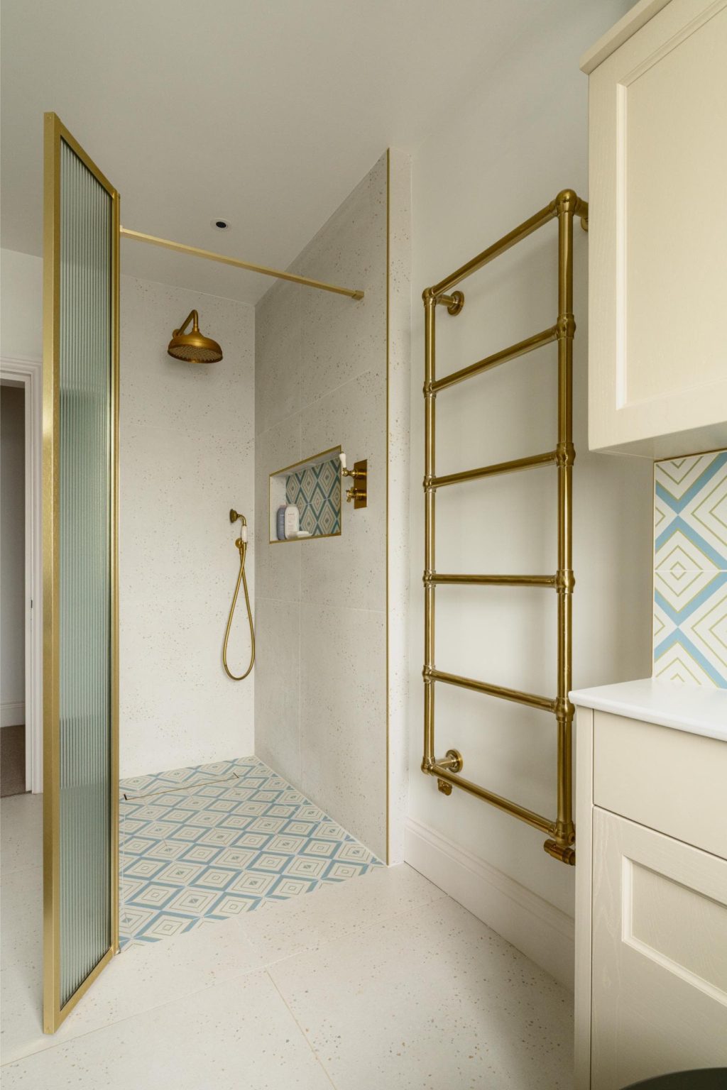 Walk-in shower with brass fittings, glass screen and heated towel rail