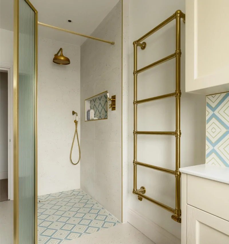 Walk-in shower with brass fittings, glass screen and heated towel rail