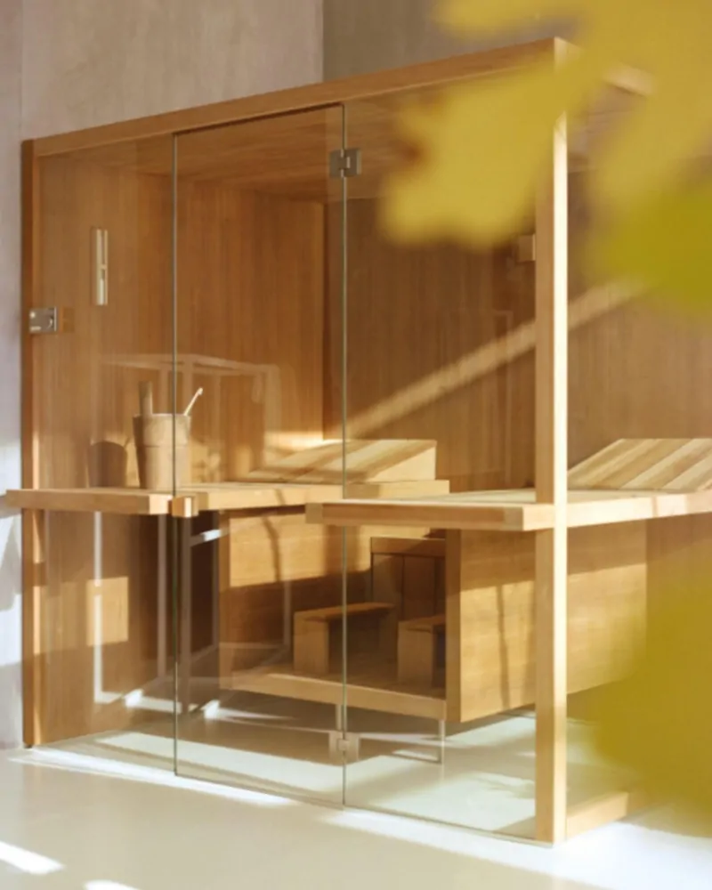 Luxury home sauna with glass enclosure and warm timber interior