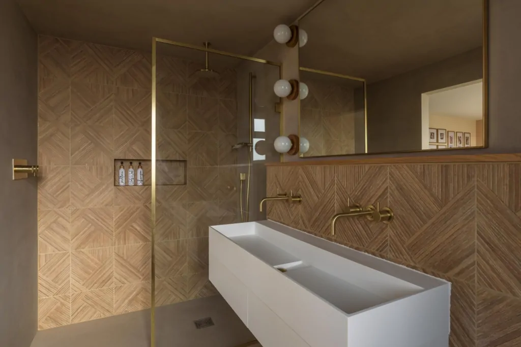 Walk-in shower with warm brown tiles, glass screen and contemporary fittings
