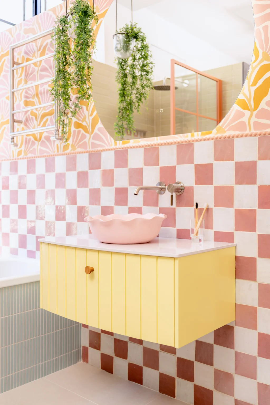 Bespoke bathroom showroom display with pink tiled walls, freestanding bath and premium bathroom fixtures