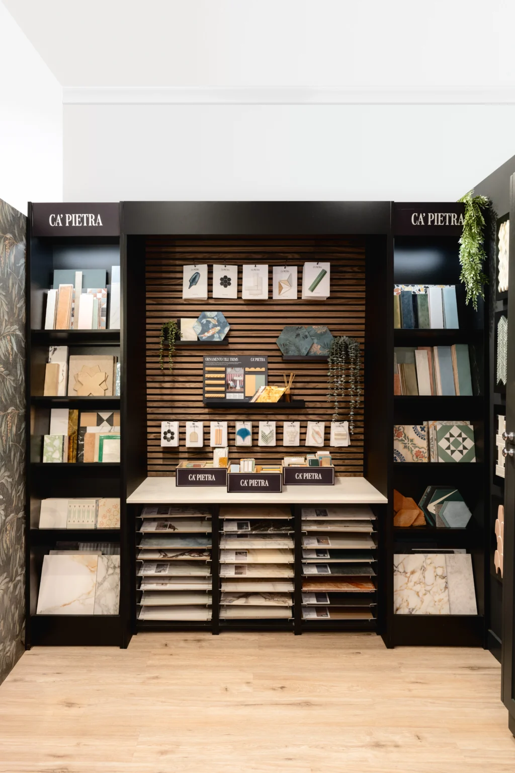 High-end bathroom showroom display featuring dark cabinetry, shelving and luxury bathroom accessories