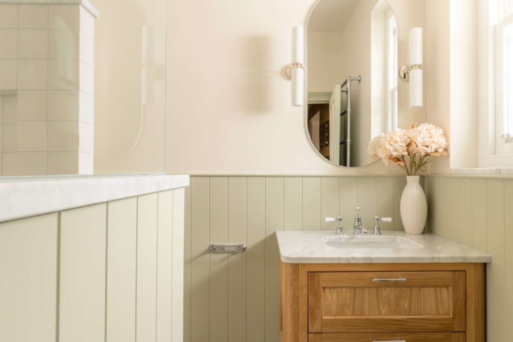 Hampton family bathroom in Hove with an oak vanity, marble worktop, sage panelling and Ca' Pietra basketweave mosaic floor.