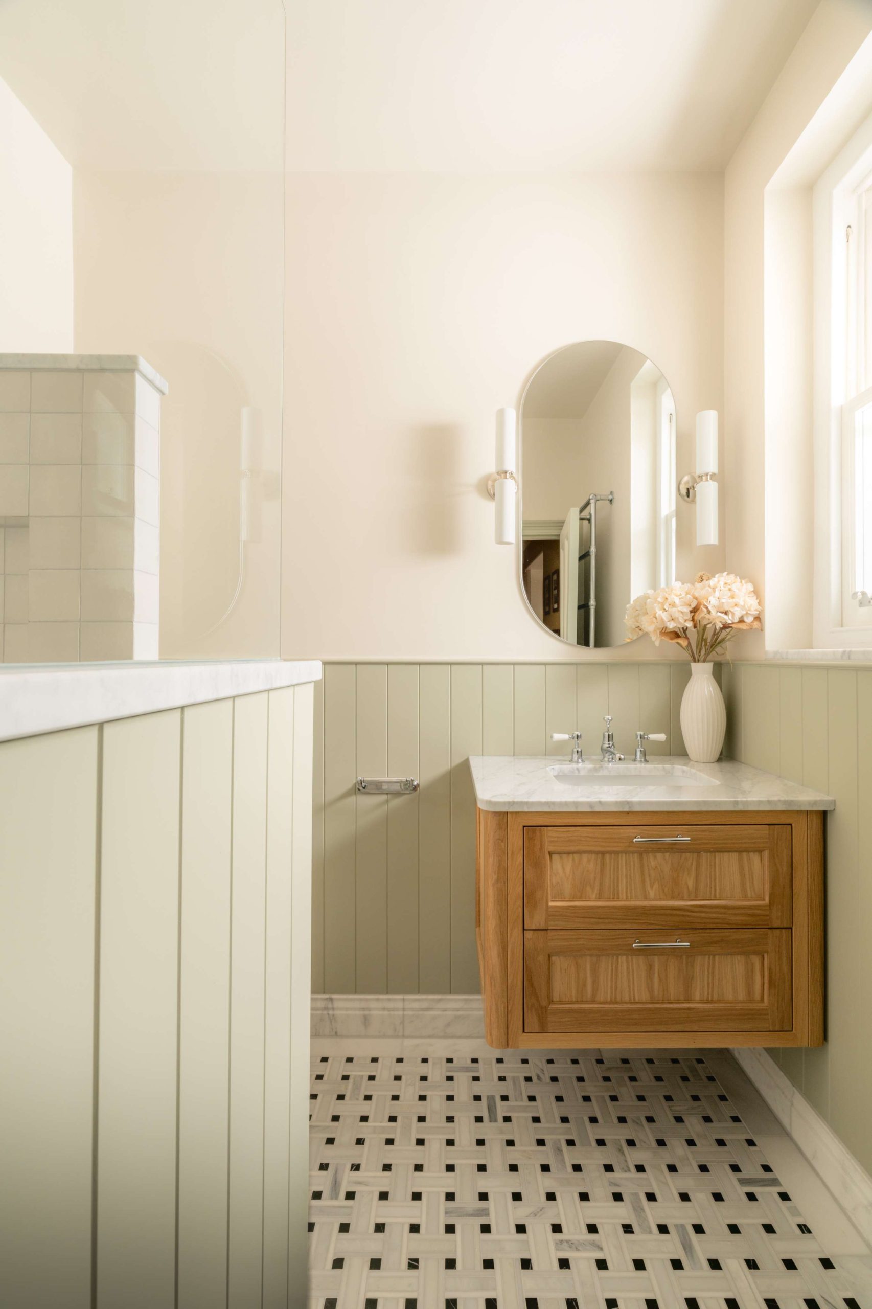 Hampton family bathroom in Hove with an oak vanity, marble worktop, sage panelling and Ca' Pietra basketweave mosaic floor.