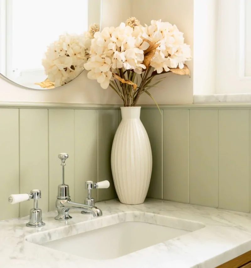Marble basin with traditional polished chrome Burlington taps, framed by soft sage wall panelling and a light oak vanity.